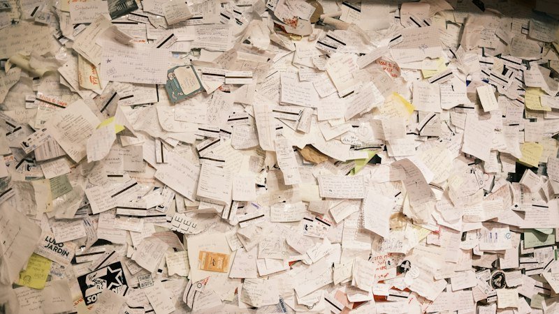 A large pile of loose paper receipts and statements waiting to be sorted