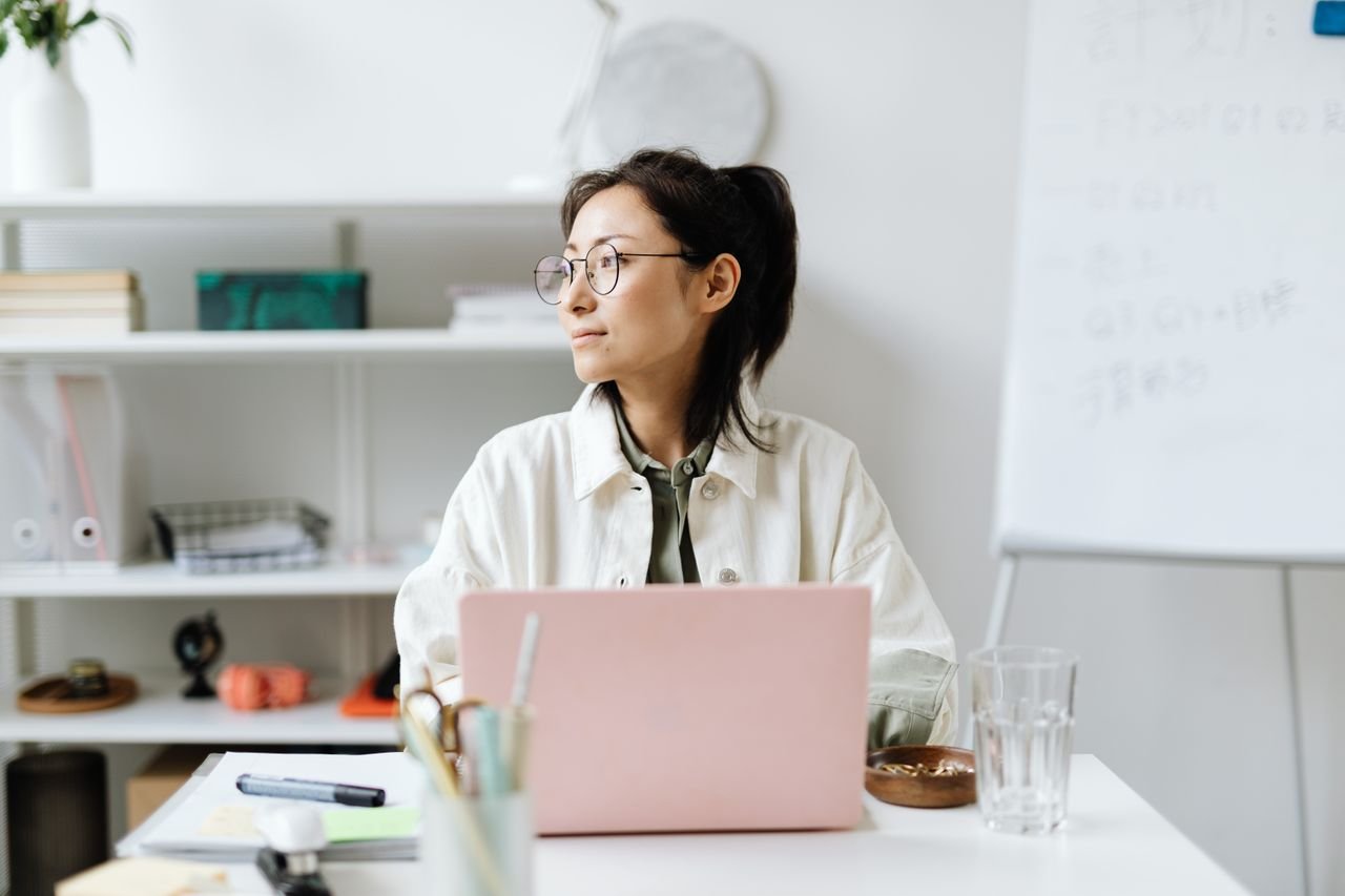 A bookkeeper working at a laptop in a bright office